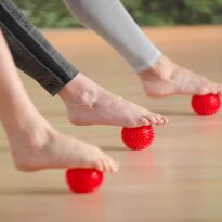 drei Füße massieren Fußinnenfläche mit Igelball