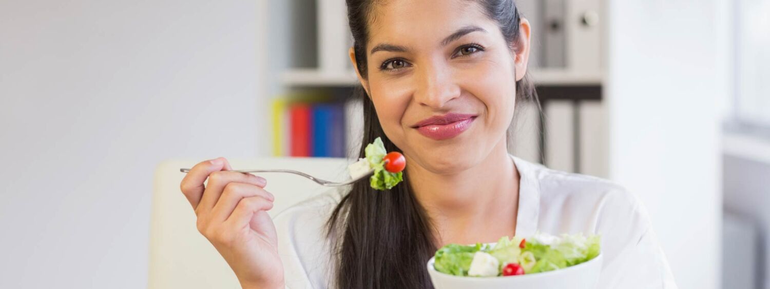 Junge Frau isst Salat - Gesund Essen und Trinken - Ernährung im Alltag